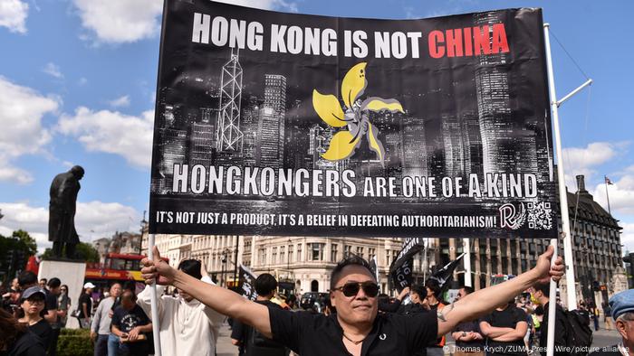 In London, a man demonstrates with a banner for more democracy in Hong Kong