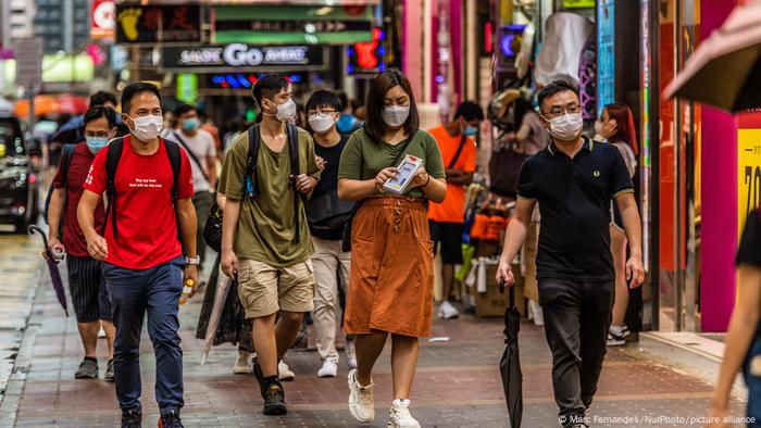 People wearing masks walking through the streets of Hong Kong