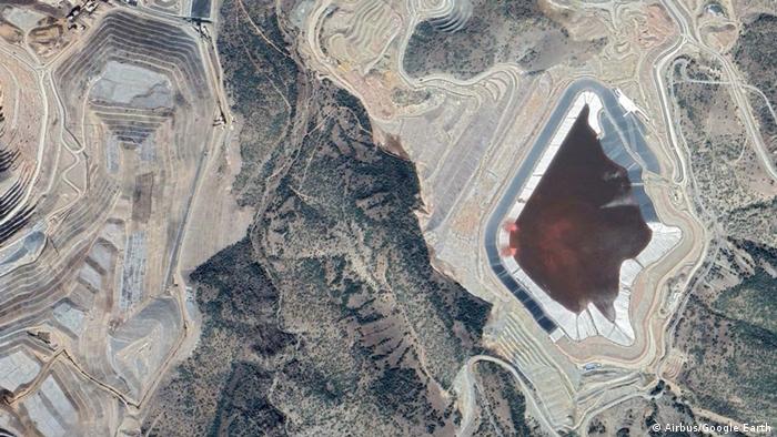 A satellite image of an open pit gold mine.  A pool of cyanide is visible.