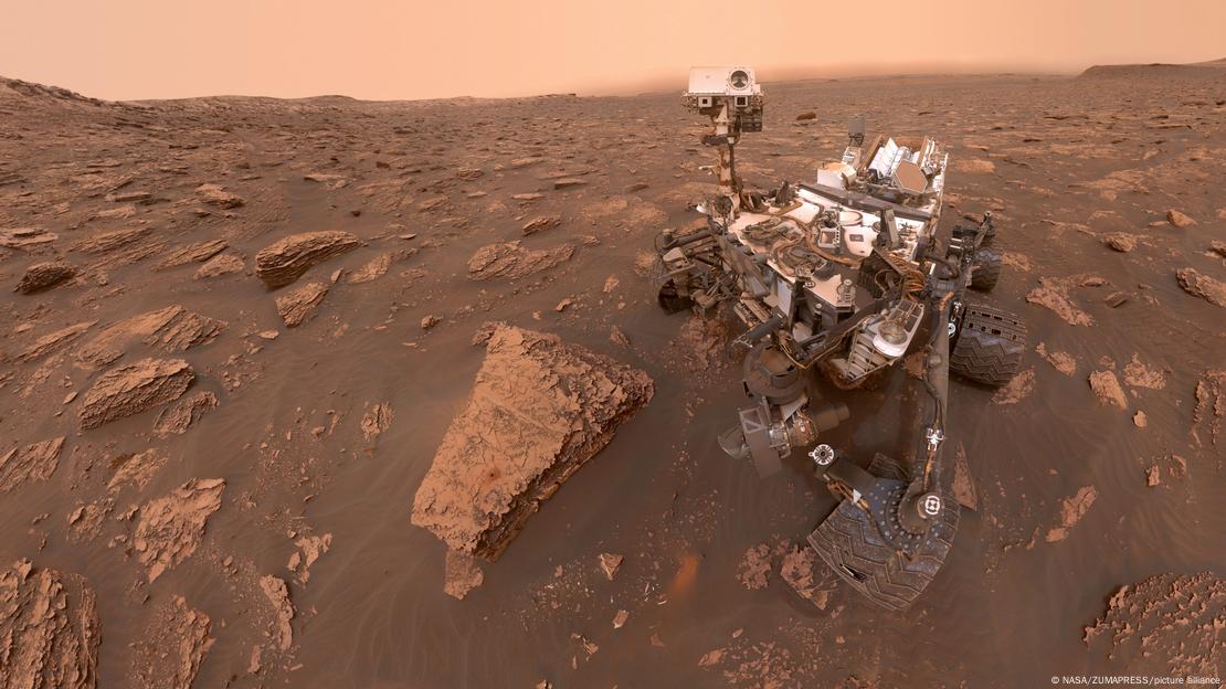 El róver Curiosity en una superficie de polvo y rocas. El róver Curiosity en una superficie de polvo y rocas.