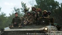 Ukrainian soldiers ride on an armored personnel carrier (APC) on a road of the eastern Luhansk region on June 23, 2022, amid Russia's military invasion launched on Ukraine. - On the road between the towns of Siversk and Bakhmut, AFP journalist witnessed several shellings on the route, which is now the main itinerary being used to reach the city of Lysychansk, since a highway has long been under shelling. Driving out of the devastated eastern Ukrainian city of Lysychansk on June 23, the journalists twice had to jump out of cars and lie on the ground as Russian forces shelled the city's main supply road. The three shelling incidents they witnessed took place on a stretch of road approximately 5 kilometres (3 miles) long. (Photo by Anatolii Stepanov / AFP) (Photo by ANATOLII STEPANOV/AFP via Getty Images)