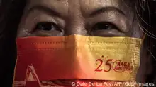 2022年7月1日，一名香港婦女戴著印有標語的口罩慶祝香港從英國移交給中國25週年。