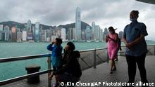People stand by the shore as the Hong Kong Observatory raised its No.8 storm warning, in Hong Kong, Saturday, July 2, 2022. Typhoon Chaba is buffeting Hong Kong, bringing high winds and plenty of rain, but no serious damage, as of midday Saturday. (AP Photo/Kin Cheung)