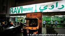 People dine out next to Ravi X Adidas truck in front of the Ravi restaurant in Satwa district of Dubai, United Arab Emirates, Wednesday, June 22, 2022. Adidas has teamed up with Dubai nostalgic family-owned Pakistani restaurant to release the Superstar Ravi sneaker. (AP Photo/Kamran Jebreili)