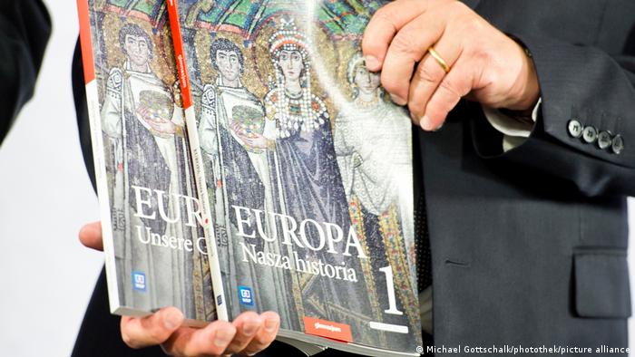 Federalny minister spraw zagranicznych Frank-Walter Steinmeier trzyma niemiecki i polski egzemplarz książki podczas prezentacji pierwszego tomu podręcznika 