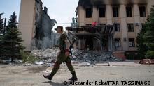 LISICHANSK, UKRAINE JULY 3, 2022: LPR serviceman walks past a building of the Lisichank military and civil administration destroyed in shelling. The Russian Armed Forces are carrying out a special military operation in Ukraine in response to requests from the leaders of the Donetsk People s Republic and Lugansk People s Republic for help. Alexander Reka/TASS PUBLICATIONxINxGERxAUTxONLY TS138D76