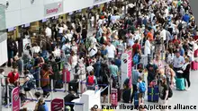 DUSSELDORF, GERMANY - JUNE 25: People wait in long lines amid summer travel chaos due to lack of personnel at Dusseldorf International Airport in Dusseldorf, North Rhine-Westphalia, Germany on June 25, 2022. Flight delays and cancellations continued to stall air travelers. Kadir Ilboga / Anadolu Agency