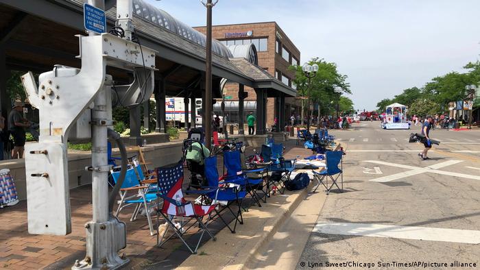Empty camping chairs line a street