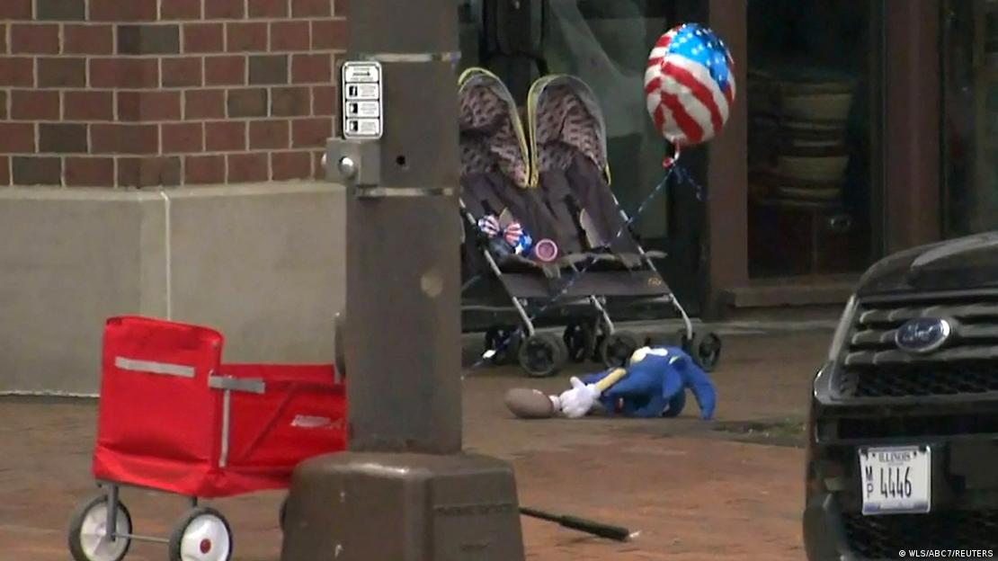 Foto mostra dois carrinhos de bebês abandonados, com um balão com a bandeira dos EUA. No chão, um boneco.