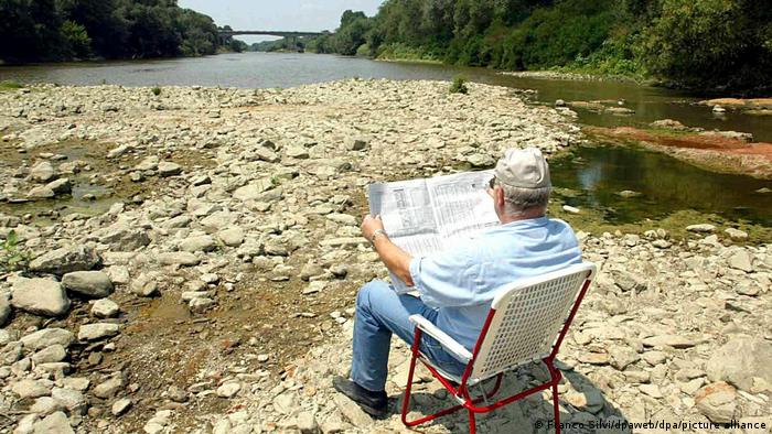 Čovjek čita novine u suhom koritu rijeke Arno