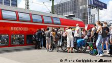 Fahrgäste warten in einer Schlange am Bahnsteig des Karlsruher Hauptbahnhofs auf den Einstieg in den Regionalexpress. Seitdem man das 9-Euro-Ticket kaufen kann, bilden sich große Menschentrauben an den Bahnhöfen.