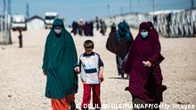 Women with children walk at Camp Roj, where relatives of people suspected of belonging to the Islamic State (IS) group are held, in the countryside near al-Malikiyah (Derik) in Syria's northeastern Hasakah province, on March 28, 2021. - Roj, one of two Kurdish-run displacement camps housing foreign family members of suspected IS fighters, is smaller and better guarded than its overcrowded counterpart Al-Hol, which has been rocked by assassinations and breakout attempts in recent months. (Photo by Delil SOULEIMAN / AFP) (Photo by DELIL SOULEIMAN/AFP via Getty Images)