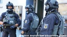 Close up photo of three armed German police officers in Osnabrück wearing helmets, balaclavas, and body armor, taken on July 5, 2022, during the operation