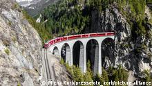 Aussicht auf das Landwasserviadukt in der Schweiz. Ein Zug der Rhätischen Bahn (RhB) passiert das Viadukt. 20.05.2022