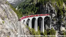 Aussicht auf das Landwasserviadukt in der Schweiz. Ein Zug der Rhätischen Bahn (RhB) passiert das Viadukt. 20.05.2022
