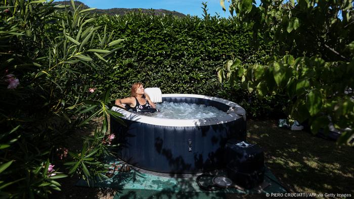 Marina Piceno, 64, takes a bath in her garden, in an inflatable pool that uses water from her private well, on June 17, 2022 in Brovello-Carpugnino, some 70 km north of Milan, Italy.