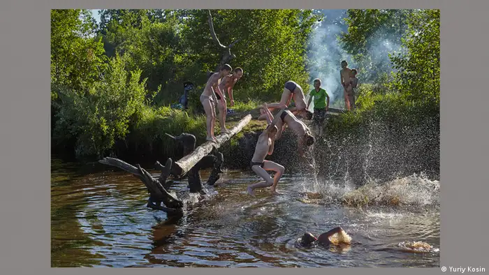 Jungen springen in einen Fluss.