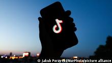 TikTok logo displayed on a phone screen and a view of the city in the background are seen in this illustration photo taken in Krakow, Poland on June 6, 2022. (Photo by Jakub Porzycki/NurPhoto)