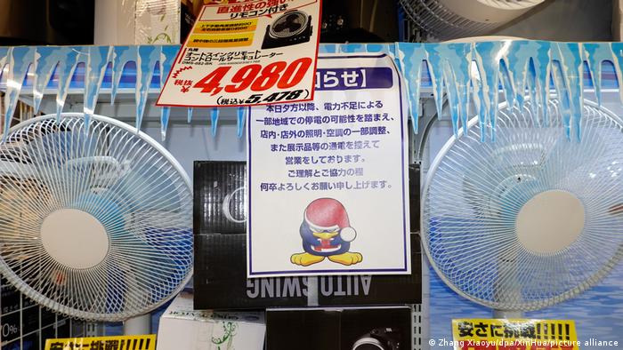Supermercado japonés: entre dos ventiladores cuelga un letrero instando a los consumidores a ahorrar energía. 