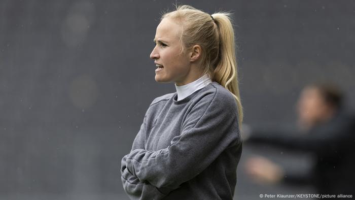 Theresa Merk steht mit verschränkten Armen am Spielfeldrand Theresa Merk steht mit verschränkten Armen am Spielfeldrand