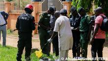Security officers inspect items suspected to be explosives outside the medium-security prison in Kuje