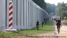 Polish border guards patrol the area of a newly built metal wall on the border between Poland and Belarus, near Kuznice, Poland, Thursday, June 30, 2022. A year after migrants started crossing into the European Union from Belarus to Poland, Polish Prime Minister Mateusz Morawiecki and top security officials visited the border area on Thursday to mark the completion of a new steel wall. (AP Photo/Michal Dyjuk)