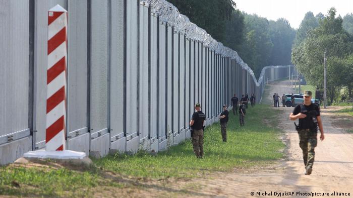 Members of the Polish security forces patrol the border wall with Belarus