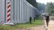 Polish border officials guard a metal wall on its border with Belarus Polish border officials guard a metal wall on its border with Belarus
