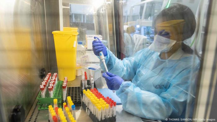 Female researcher in protective clothing handling COVID samples for sequencing in a French hospital