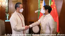 In this photo provided by the Malacanang Presidential Photographers Division, Philippine President Ferdinand Marcos Jr., right, greets Chinese Foreign Minister Wang Yi as the arrives for a courtesy call at the Malacanang Presidential Palace in Manila, Philippines on Wednesday, July 6, 2022. (Malacanang Presidential Photographers Division via AP)