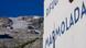 A sign reading 'Marmolada' with the mountain slope visible in the distance A sign reading 'Marmolada' with the mountain slope visible in the distance