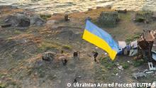 Ukrainian service members install a national flag on Snake (Zmiinyi) Island, as Russia's attack on Ukraine continues, in Odesa region, Ukraine, in this handout picture released July 7, 2022. Press service of the Ukrainian Armed Forces/Handout via REUTERS ATTENTION EDITORS - THIS IMAGE HAS BEEN SUPPLIED BY A THIRD PARTY.