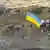 Ukrainian service members install a national flag on Snake Island