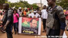 A man holds a poster depicting Blaise Compaore, former President of Burkina Faso, in front of Ouagadougou airport on July 7, 2022 as they await his return 8 years after he was forced into exile in Ivory Coast in 2014. (Photo by Olympia DE MAISMONT / AFP)