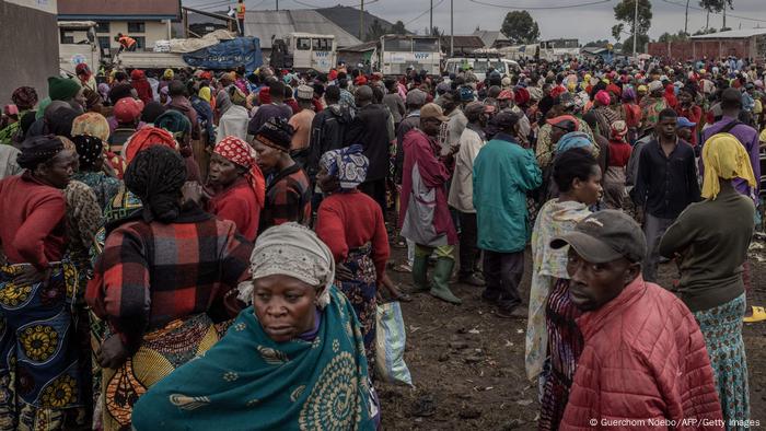 Displaced people wait for food in a camp in Goma