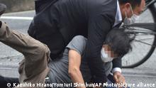 A man, believed to be a suspect shooting Japanese Prime Minister Shinzo Abe is held by police officers at Yamato Saidaiji Station in Nara Prefecture on July 8, 2022. 67-year-old Abe has reportedly been shot in the chest during a stumping tour in Nara in the morning on July 8. ( The Yomiuri Shimbun via AP Images )