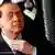 Silvio Berlusconi with his hands over his face
