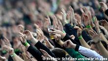 MOENCHENGLADBACH, GERMANY - OCTOBER 31: Fans show their support as one holds a beer during the Bundesliga match between Borussia Mönchengladbach and VfL Bochum at Borussia-Park on October 31, 2021 in Moenchengladbach, Germany. (Photo by Frederic Scheidemann/Getty Images)