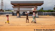 ARCHIV 2019 *** A woman and children walk by an empty filling station on the Owode-Apa road, in Badagry, near Lagos, on September 6, 2019. (Photo by Benson IBEABUCHI / AFP)