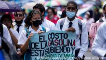 High school students hold a banner that reads in Spanish The cost of gasoline is going up and the opportunity to live is going down during a teachers' union march to the National Assembly to protest inflation in Panama City, Friday, July 8, 2022. Public school teachers have been on strike since July 6 and announced on Friday the strike will be indefinite amid demands gas prices be fixed under $6 dollars per gallon and the cost of food come down. (AP Photo/Arnulfo Franco)