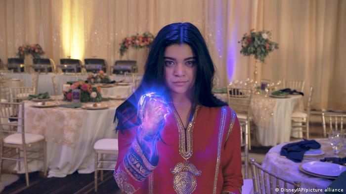 Still from 'Ms. Marvel' girl wearing a traditional kurta with lit hand forming a fist.