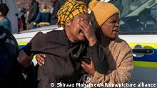 10.07.2022 Eine Frau weint am Tatort, nachdem in einer Bar Schüsse gefallen sind. In einer Kneipe im südafrikanischen Soweto sind in der Nacht zu Sonntag, dem 10.07.2022, mindestens 15 Menschen erschossen worden. Kurz nach Mitternacht seien die maskierten Täter in das Lokal in einer Slumsiedlung gekommen und hätten das Feuer eröffnet, sagte der Leiter der Polizei der Provinz Gauteng auf einer Pressekonferenz. Sie hätten «wahllos geschossen» und hochkalibrige Waffen verwendet. Zu den Motiven könne bislang nichts gesagt werden. +++ dpa-Bildfunk +++