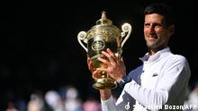 Serbia's Novak Djokovic poses with his trophy afterdefeating Australia's Nick Kyrgios during the men's singles final tennis match on the fourteenth day of the 2022 Wimbledon Championships at The All England Tennis Club in Wimbledon, southwest London, on July 10, 2022. (Photo by SEBASTIEN BOZON / AFP) / RESTRICTED TO EDITORIAL USE