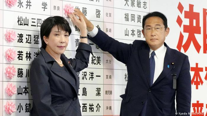 El primer ministro japonés, Fumio Kishida, y la jefa de política del PLD, Sanae Takaichi, colocan una escarapela con el nombre de un candidato del partido que aseguró su victoria en las elecciones a la Cámara de Consejeros el 10 de julio de 2022.