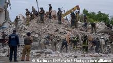 Rescue workers sift through rubble at the scene in the after math of a Russian rocket that hit an apartment residential block, in Chasiv Yar, Donetsk region, eastern Ukraine, Sunday, July 10, 2022. At least 15 people were killed and more than 20 people may still be trapped in the rubble, officials said Sunday. (AP Photo/Nariman El-Mofty)