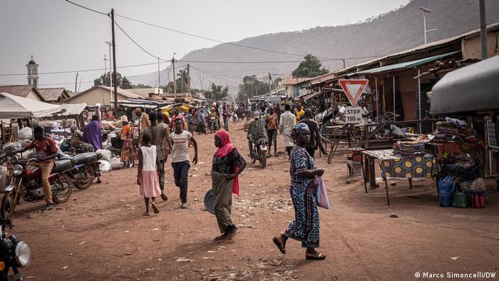 Locals wandering along a dirt street in Tanguieta, a town in Benin's Atacora region