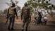 Two armed soliders approach a motorcyclist at a checkpoint near Porga, northern Benin Two armed soliders approach a motorcyclist at a checkpoint near Porga, northern Benin