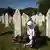 A Bosnian muslim woman prays at a grave of one of the victims of the Srebrenica massacre