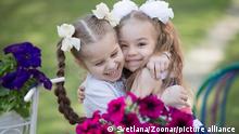 Two little six-year-old girlfriends embrace against a background of bright colors. Children's friendship. || Modellfreigabe vorhanden