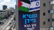 A billboard by Israeli anti-occupation group Peace Now, welcoming US President Joe Biden, hangs on a building in the coastal city of Tel Aviv on July 11, 2022, ahead of his visit this week. The billboard reads in Hebrew: President Biden, welcome to the two countries we love the most. (Photo by JACK GUEZ / AFP)
